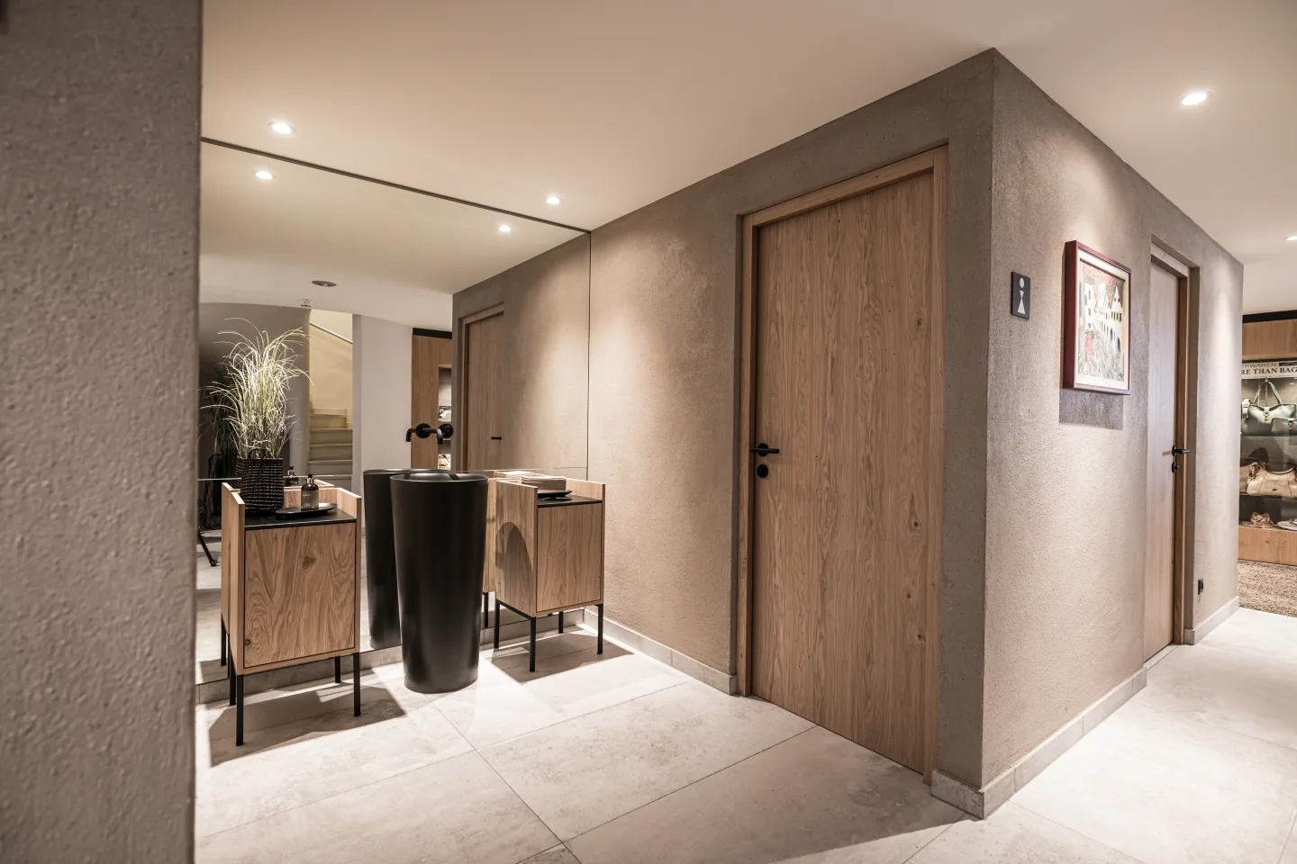 Waschraum mit Scheibenputz in hellem braun, raumhoher Spiegel, Waschtische davor.